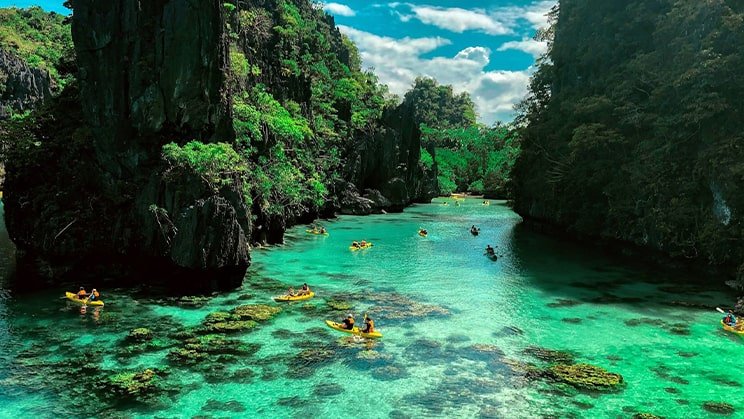 tourists kayaking green waters of big lagoon in el nido palawan philippines